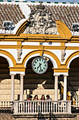 Seville, Spain Aug 15 2007, People gather beneath the clock at Real Maestranza bullring, admiring its stunning architecture in Seville, Spain, on a sunny day.