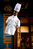 A chef mannequin dressed in uniform hangs in a vibrant Barcelona shop on Hospital Street, located in the bustling Raval neighborhood.