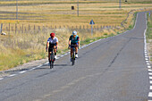 Two riders cycling in the road of La Lancha, a mountain pass in the province of Ávila.