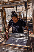 A young woman weaving on a wooden foot loom in Seclantas, Argentina in the Calchaqui Valley.