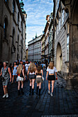 Young girls walking in Prague, view from behind