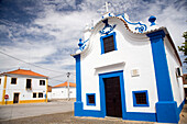 Die weiß-blaue Iglesia de Motrinos steht in dem charmanten Dorf Reguengos de Monsaraz unter einem bewölkten Himmel