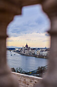 Parliament building and Danube River, viewed through old columns, Budapest, Hungary, Europe