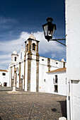 Die Wehrkirche in Monsaraz steht prominent unter einem hellen Himmel, der ihre Architektur und historische Bedeutung hervorhebt