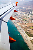 Overlooking the vibrant town of Malaga, Spain, with stunning coastal views and urban development from a plane in flight.