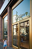 Berlin, Germany, July 27 2009, A young girl walks past a stylish shop window, reflecting the vibrant street life of Berlin\'s Mitte district.