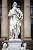 The statue of Friedrich Schiller overlooks Gendarmenmarkt square, highlighting the architecture of Berlin’s renowned Konzerthaus.