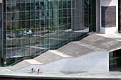 Cyclists navigate the striking steps of the Marie-Elisabeth-L?ders Building in Berlin?s Mitte district, showcasing modern architecture.