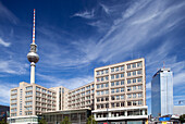 Visitors admire the iconic landmarks at Alexanderplatz square in Berlin under a clear blue sky.