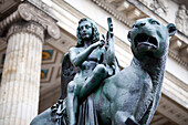 A detailed bronze statue featuring a winged figure riding a lion outside the Konzerthaus in Gendarmenmarkt, Berlin.