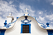 The ornate facade of Motrinos church showcases its beautiful blue and white design under a cloudy sky in Alentejo.