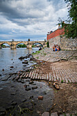 Menschen amüsieren sich am Ufer der Moldau, Prag