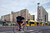 Berlin, Germany, July 21 2009, A cyclist pedals past modern buildings on Karl-Liebknecht street in Berlin as tram services operate nearby during the evening.