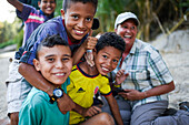 Group of playful local kids having fun with a foreigner woman, Santa Marta, Colombia