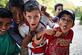 Group of playful local kids having fun with a foreigner woman, Santa Marta, Colombia