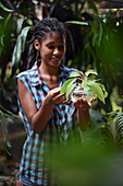 Young afro latin woman gardening and holding an hydroponic plant