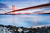 Forth Road Bridge and the red Forth Bridge railway crossing, UNESCO World Heritage Site, beyond, lit by evening light, view from the FA?rth of Forth in South Queensferry, near Edinburgh, Scotland, United Kingdom, Europe