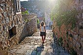 Woman walking down cobbled steps, Lastovo town, Lastovo island, Croatia, Southeast Europe