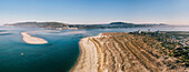 Aerial drone panoramic view of Troia, a peninsula located in Grandola Municipality, next to Sado River estuary, with Arrabida mountain range on left, Alentejo, Portugal, Europe