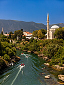 Boats on the Neretva River cutting through Mostar, Bosnia and Herzegovina, Europe