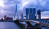 Blaue Stunde mit Sonnenuntergangslicht und moderner Skyline am Fluss Mass mit Erasmusbrücke, Rotterdam, Niederlande, Europa