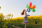 Little girl playing with balloons in the fields, Eure-et-Loir department, Centre region, France, Europe