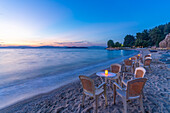 View of restaurant tables on beach after sunset, Thassos Town, Thassos, Aegean Sea, Greek Islands, Greece, Europe