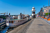 Blick auf den Osloer Leuchtturm und Cafés am Wasser, Aker Brygge, Oslo, Norwegen, Skandinavien, Europa