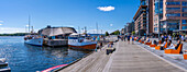 View of boat and sun loungers at the waterfront, Aker Brygge, Oslo, Norway, Scandinavia, Europe