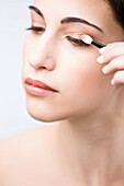 Profile up of a young woman applying eyeshadow