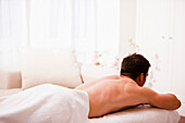 Back view of a man lying on his stomach on a treatment bench