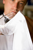 Waiter polishing a wine glass