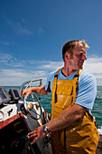 Close up of a fisherman driving a boat