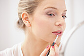 Woman Applying Lipstick with Makeup Brush