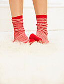 Woman's Feet with Red and White Wool Socks on Fluffy Rug