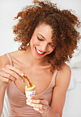 Smiling Woman Dipping Toast in Soft Boiled Egg