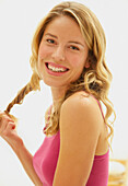 Smiling Woman Twisting Strand of Hair