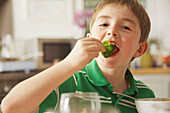 Young Boy Eating Broccoli