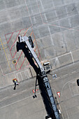 View from above passenger boarding bridge over sunny airport tarmac