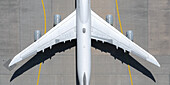 View from above white airplane on sunny airport tarmac