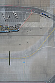 View from above luggage carts and road markings on sunny airport tarmac