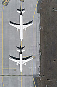 View from above white airplanes waiting on sunny airport runway