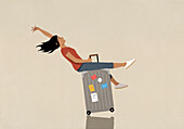 Carefree woman riding suitcase