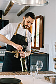 Privatkoch öffnet Wein in rustikaler Küchenumgebung