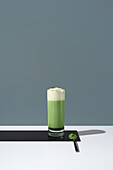 Refreshing matcha tea with cream against a minimalist backdrop