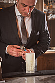 Barkeeper beim Brennen von Cocktailgarnituren an der Theke