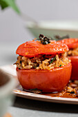 Stuffed tomatoes with brown rice and nuts on a ceramic plate