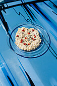 Babaganoush with pomegranate on blue car hood in outdoor setting