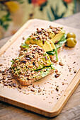 Avocado toast with pits on a wooden board