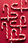 Top view of traditional candy canes on red background